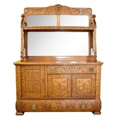 an old wooden dresser with mirror on top and carvings around the bottom, in front of a white background