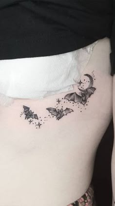 a woman's lower back with bats and stars on her side ribcage