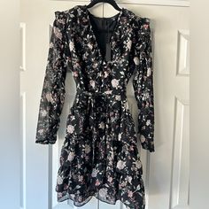 Black Floral, Long Sleeve Dress With Ruffle Details Along Neckline, Shoulders, Down The Sleeves, 4 Tiers Of Ruffles On Lower Half Of Dress. With Matching Tie Belt, Zipper In Back. Hits Above Knee. Bust Pit-Pit 19 Length 35 Waist 15.5 Black Knee-length Floral Dress For Brunch, Black Floral Knee-length Dress For Brunch, Chic Black Knee-length Floral Dress, Chic Long Sleeve Black Floral Dress, Chic Black Floral Long Sleeve Dress, Chic Black Long Sleeve Floral Dress, Black Floral Dress For Date Night, Fall Black Lined Dresses, Floral Long Sleeve Dress