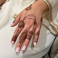 a woman's hand with henna tattoos on it