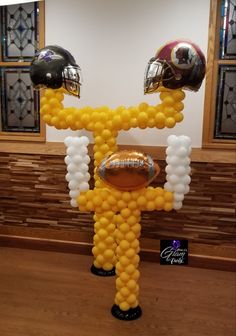 a balloon sculpture made to look like a football player wearing a helmet and holding a football