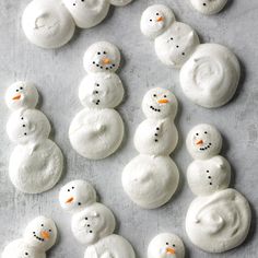 frosted snowmen are arranged on a baking sheet