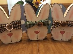 three wooden rabbits with bows on their ears