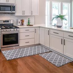 a kitchen with white cabinets and stainless steel stove top oven, dishwasher, microwave and refrigerator