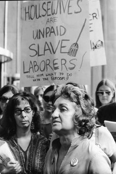 an old black and white photo of people holding signs