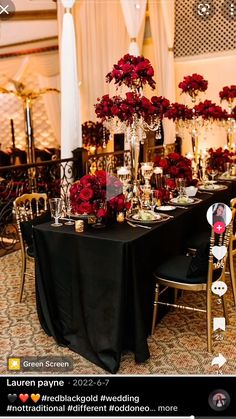 the table is set up with red flowers and candles for an elegant wedding reception or special event