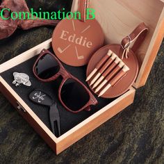 an open wooden box with sunglasses and other items