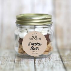 a jar filled with cookies and marshmallows on top of a wooden table