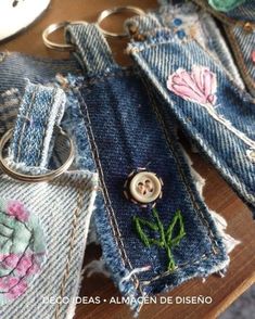 several pieces of denim with buttons and flowers on them sitting on top of a table