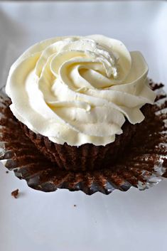 a cupcake with white frosting and chocolate sprinkles