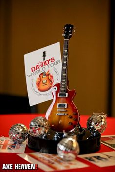 a guitar sitting on top of a table next to a sign that says david's world tour