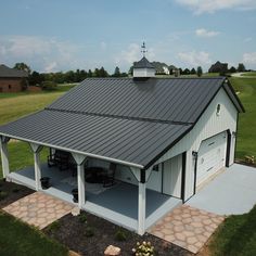 a large white barn with a black roof