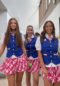 three girls dressed in school uniforms posing for the camera