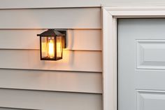 a light that is on the side of a house next to a door with a handle