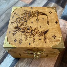 a wooden box with an image of a bird on the moon and stars around it