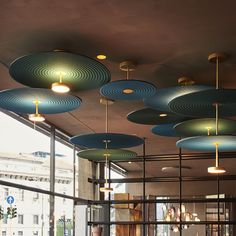 a room filled with lots of blue and yellow lamps hanging from the ceiling above it