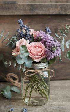 a mason jar filled with flowers and greenery