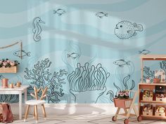 a child's room decorated in blue and white with sea animals on the wall