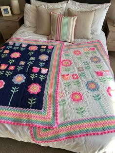 a crocheted bedspread on a bed with pillows and blankets in the shape of flowers