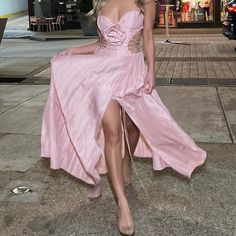 a woman in a pink dress is walking down the street