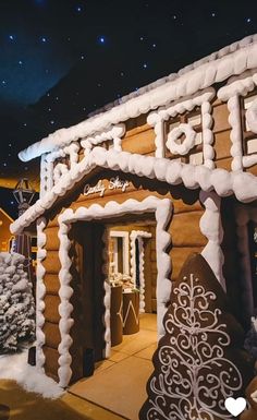 a large gingerbread house with snow on the roof