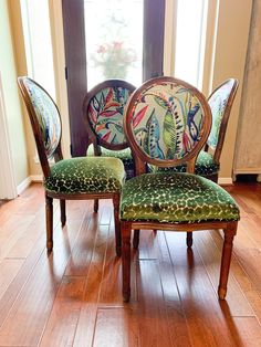 three chairs with floral designs on them sit in front of a window and hardwood floor