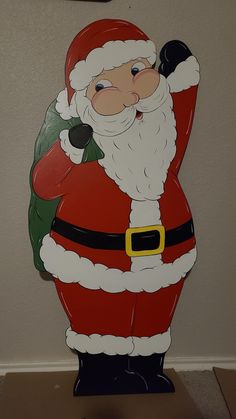 a santa clause standing next to a wall