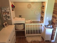 a baby's room with a crib, dresser and changing table in it