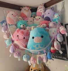 a bunch of stuffed animals hanging from a wall