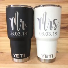 two personalized yeti tumblers sitting next to each other on a wooden surface