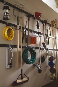 there is a rack with many different tools hanging on the wall next to each other