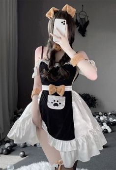 a woman taking a selfie with her cell phone wearing a dress and cat ears