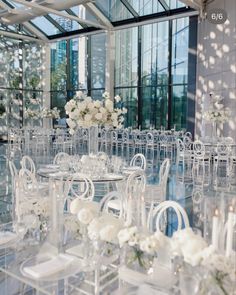 a room filled with lots of clear chairs and tables covered in white flower centerpieces