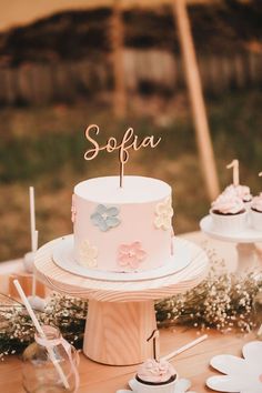 a pink cake sitting on top of a wooden table