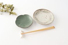 two bowls and chopsticks sitting next to each other on a white table top