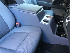 the interior of a vehicle with blue leather seats and electronic equipment in the center console