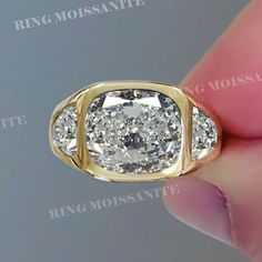 a close up of a person's hand holding a ring with a diamond in it