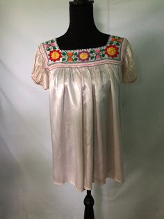 I am offering a 1940s cream satin blouse. This beautiful blouse is made of heavy rayon satin. It is luminous. It has a beautiful embroidered yoke with a colorful floral design. The sleeves are puffed with underarm  gussets. Embroidered Silk Tops For Summer, Vintage Cream Tops With Floral Embroidery, Vintage Cream Top With Floral Embroidery, Spring Silk Blouse With Floral Embroidery, Spring Embroidered Silk Blouse, Summer Silk Embroidered Blouse, Vintage Satin Tops For Spring, Silk Tops With Multicolor Embroidery, Vintage Embroidered Beige Blouse