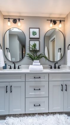 a bathroom with two sinks and three mirrors