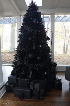 a black christmas tree with presents under it