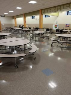 an empty classroom with tables and chairs in the middle of it, all facing away from the camera