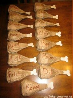 paper mache dogs with names on them sitting on a wooden table in front of an orange frame