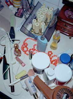 many different items are spread out on the counter top, including makeup brushes and other personal care products