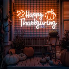 the words happy thanksgiving are lit up in front of a porch with pumpkins and gourds