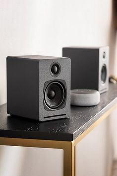 two speakers sitting on top of a table