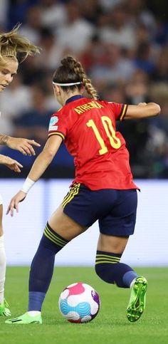 two women are playing soccer on the field