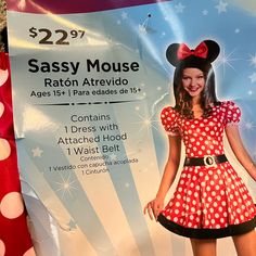 a woman in minnie mouse costume standing next to a sign