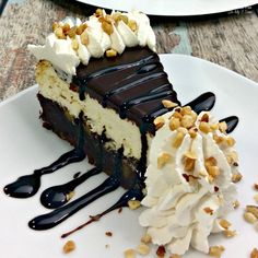 a piece of cake with whipped cream and nuts on top