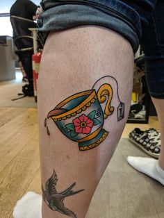 a woman's leg with tattoos on it and a bird flying in the air