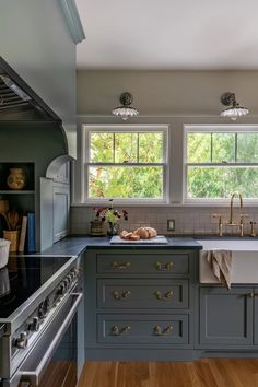 a kitchen with gray cabinets and wood floors